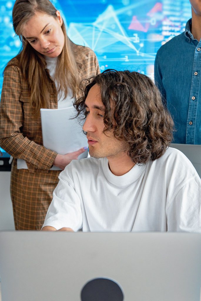 Et team diskuterer og ser på data på en laptop